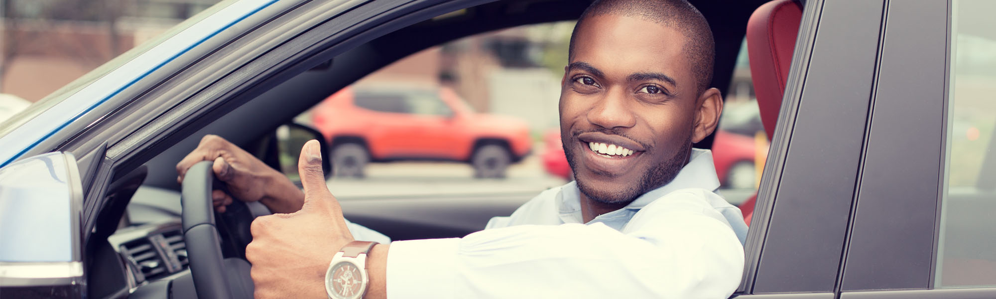 Man Giving Thumbs Up While Driving